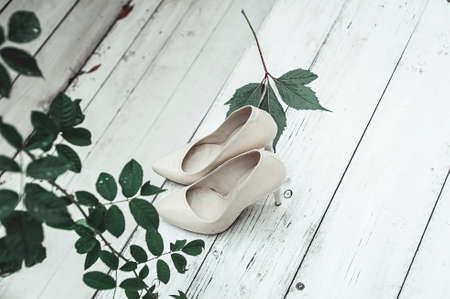 white wedding shoes in the rain on a white wooden tableの写真素材