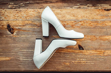Beige Wedding shoes at the yellow rustic wooden floor with cracked paintの写真素材