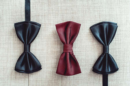 Three bow ties, two black and one red. Team work, career, hipster, wedding concept.の写真素材
