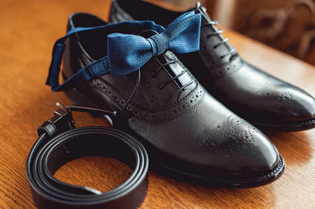 Close up of modern man accessories. Blue bow tie, leather shoes, and belt.の写真素材