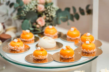 glass stand with pastry on a wedding candy bar table.