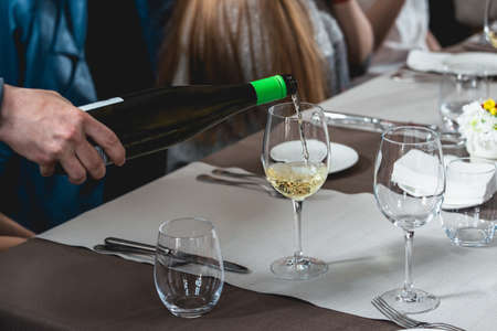 sommelier pouring wine into glass at wine and food tastingの写真素材