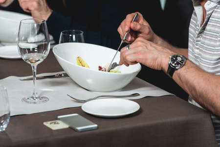 man eating delicious salmon salad in a restaurant. at the food and wine pairing. small portion.の写真素材