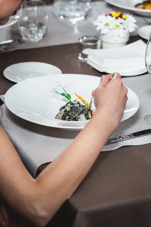 woman eating delicious salmon pasta in a restaurant. at the food and wine pairing. small portion.の写真素材