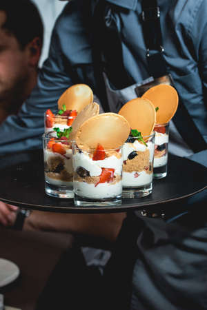 waiter serving creamy dessert with strawberry at the food and wine pairing evening the expensive restaurant. close viewの写真素材