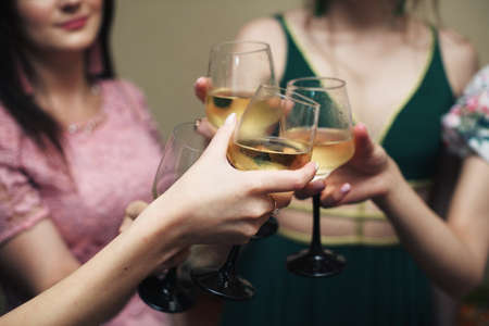 Gorls hold in hands glasses with white wine. wedding party.の写真素材