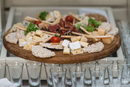 Mix cheese on wooden board with meat and bread in the restaurant
