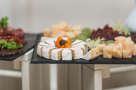 Mix cheese on a board with meat and bread in the restaurantの写真素材