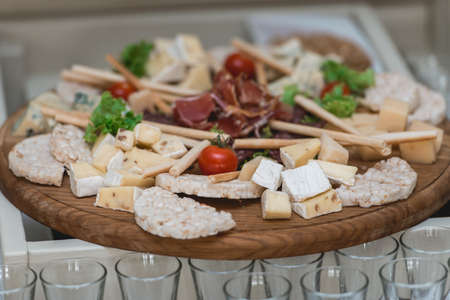 Mix cheese on wooden board with meat and bread in the restaurantの写真素材