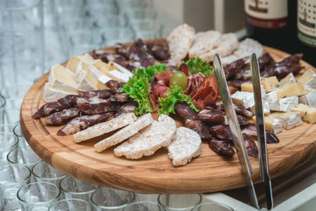 Mix cheese on wooden board with meat and bread in the restaurant