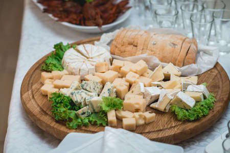 Mix cheese on wooden board with meat and bread in the restaurantの写真素材