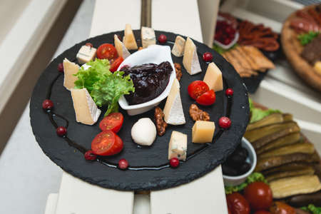 Mix cheese on wooden board with tomatosの写真素材