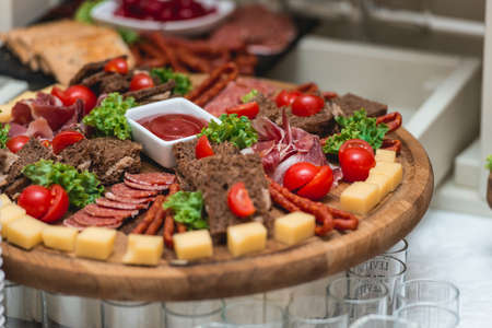 Mix cheese on wooden board with meat and breadの写真素材