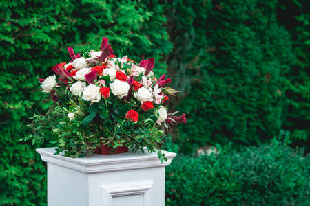 Wedding ceremony. Column, decorated with bouquet of red and white roses, in the wedding ceremony...