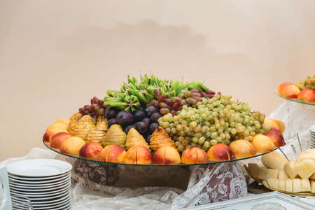 sliced fruits on a stand on a white table