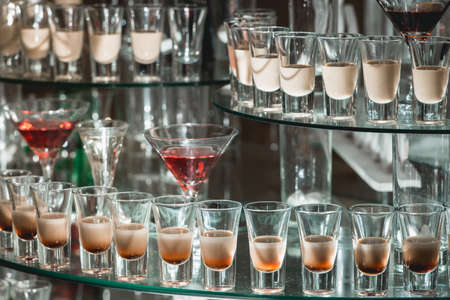 Different alcohol drinks on a glass stand. wine, champagne, cognac, vodka, martini