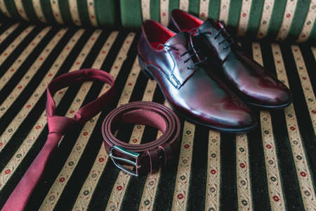 belt, necktie and shoes on a vintage sofaの写真素材