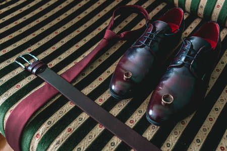 belt, necktie and shoes on a vintage sofaの写真素材