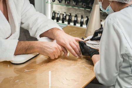 mans manicure master during nail treatmentの写真素材