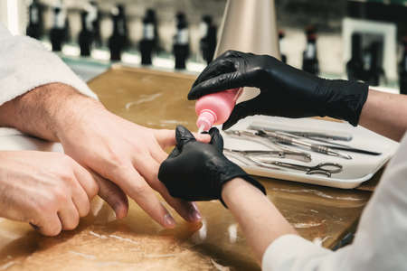 mans manicure master during nail treatmentの写真素材