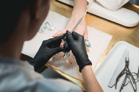 Close-up Of A Manicurist Removing old nail polish with some acetoneの写真素材