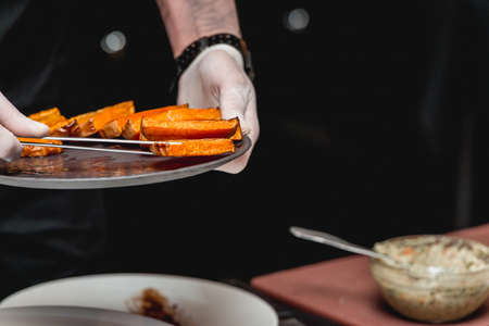 several white plates on a black table with baked sweet pumpkin and guacamole. Mexican cuisine at the restaurantの写真素材