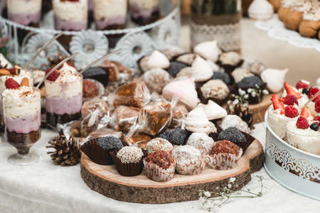 Candybar in a restaurant. Decorated white table fool of sweet pastryの写真素材