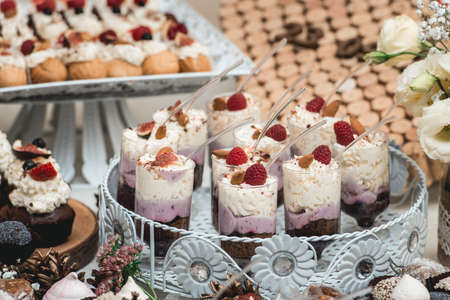 Candybar in a restaurant. Decorated white table fool of sweet pastry