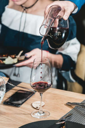 sommelier pouring champagne into glass at wine tastingの写真素材