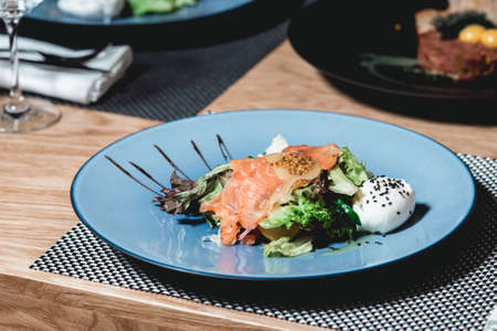 delicious salmon salad with egg in a restaurant. small portionの写真素材