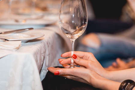 woman holds glass of red wine. people consider the color of the wine and try how it smells in different glassesの写真素材