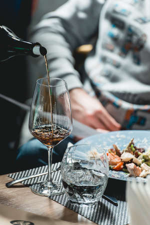sommelier pouring wine into glass at wine tastingの写真素材