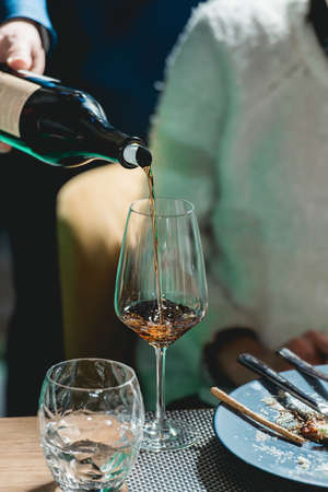 sommelier pouring wine into glass at wine tastingの写真素材