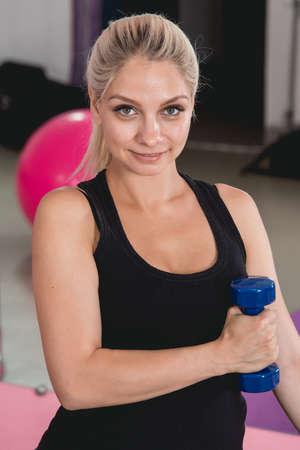 Pregnant female do exercise in sports hall, side view, body part, lifting dumbbells, active and sportive pregnancy, healthy motherhood conceptの写真素材