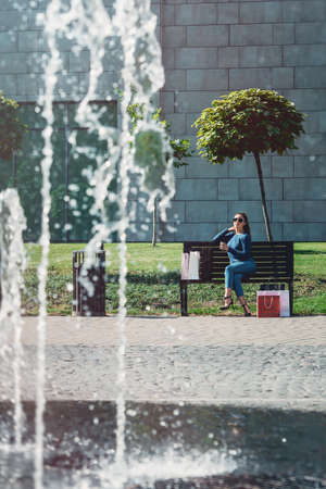 Beautiful girl with paper bags outside shopping mallの写真素材