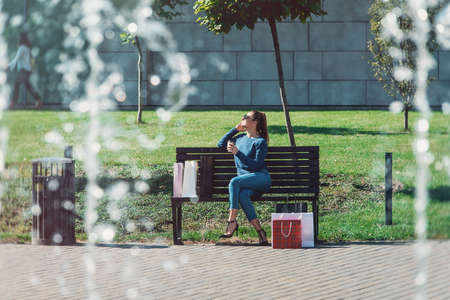 Beautiful girl with paper bags outside shopping mallの写真素材