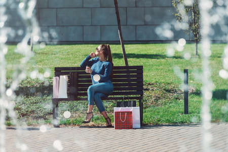 Beautiful girl with paper bags outside shopping mallの写真素材