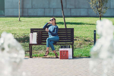 Beautiful girl with paper bags outside shopping mallの写真素材
