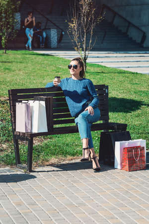 Beautiful girl with paper bags outside shopping mallの写真素材