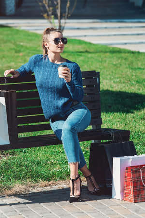 Beautiful girl with paper bags outside shopping mallの写真素材