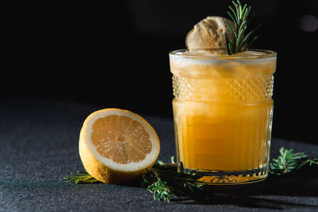 Cold Whiskey Sour Cocktail with ice and apple chips, piece of thyme on topの写真素材
