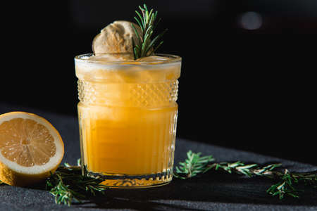 Cold Whiskey Sour Cocktail with ice and apple chips, piece of thyme on topの写真素材