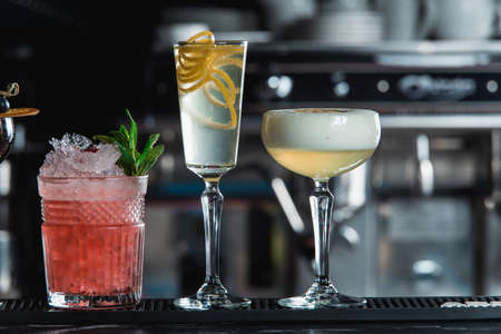 row of various colourfull alcoholic cocktails on a bar desk. Glasses of differen shapesの写真素材