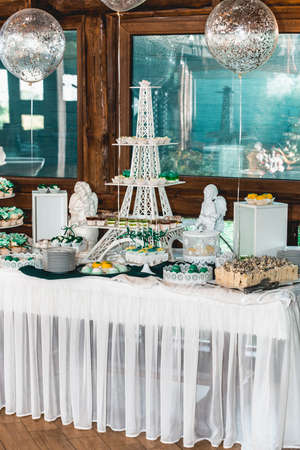 green style wedding candy bar on a white table. cupcakes decorated with a green ribbon bowの写真素材