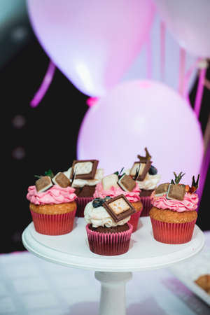 white stand with cupcakes on a candy bar tableの写真素材