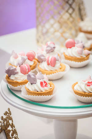 white stand with cupcakes on a candy bar tableの写真素材