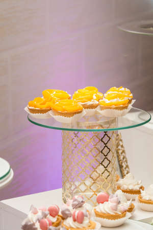 white stand with cupcakes on a candy bar tableの写真素材