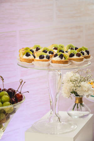 white stand with cupcakes on a candy bar tableの写真素材