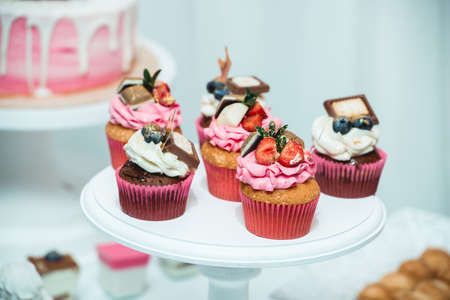 white stand with cupcakes on a candy bar tableの写真素材
