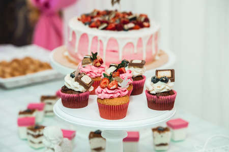 white stand with cupcakes on a candy bar tableの写真素材